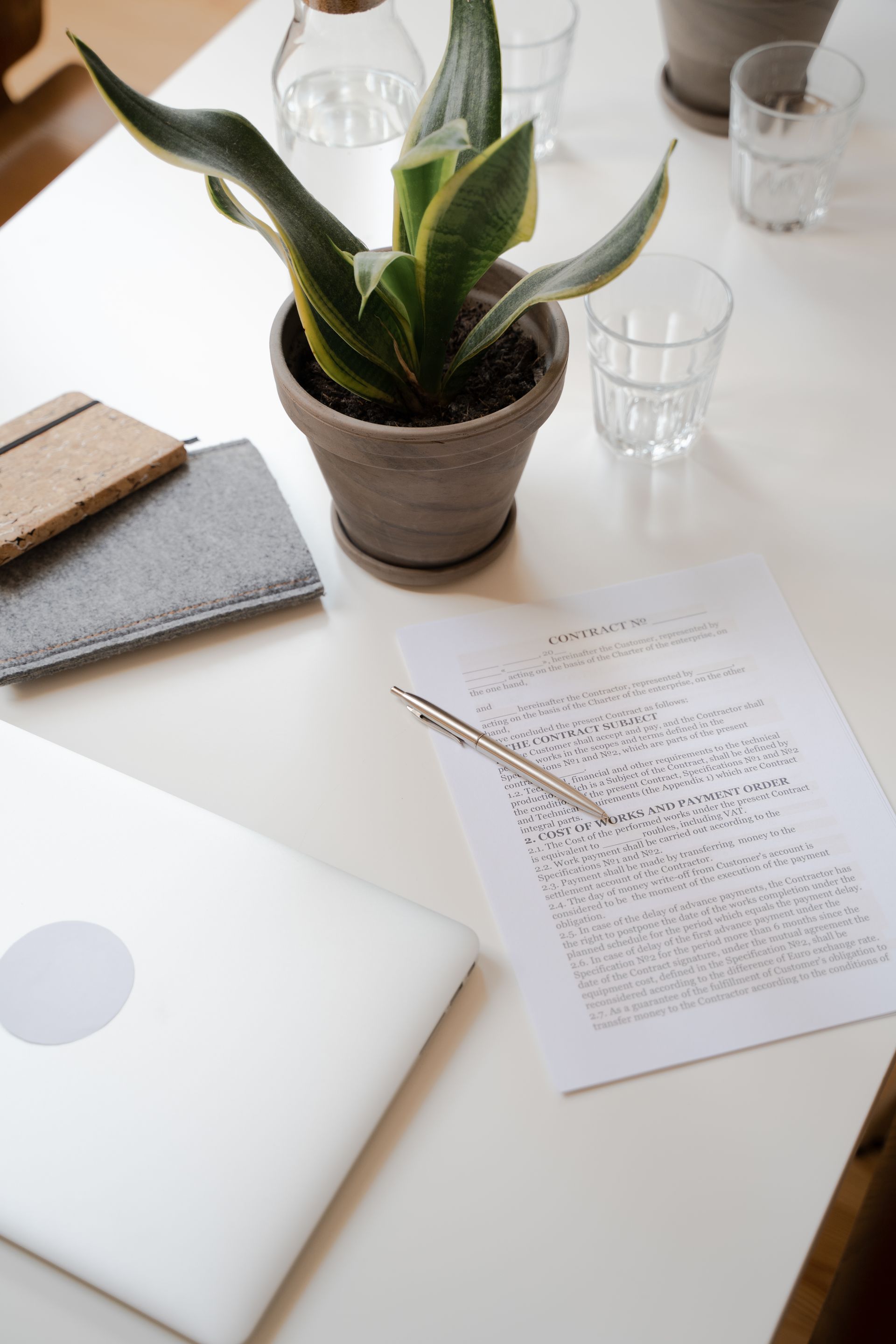 Aufgeräumter Schreibtisch mit Vertragsunterlagen, Laptop und Stift — Privatkreditvermittlung durch S&K Living